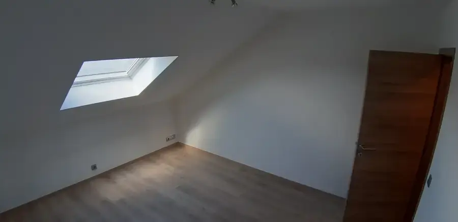 Chambre sous combles avec fenêtre de toit et parquet