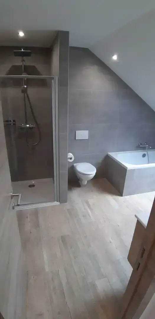Salle de bain avec douche, WC suspendu et baignoire sous mansarde