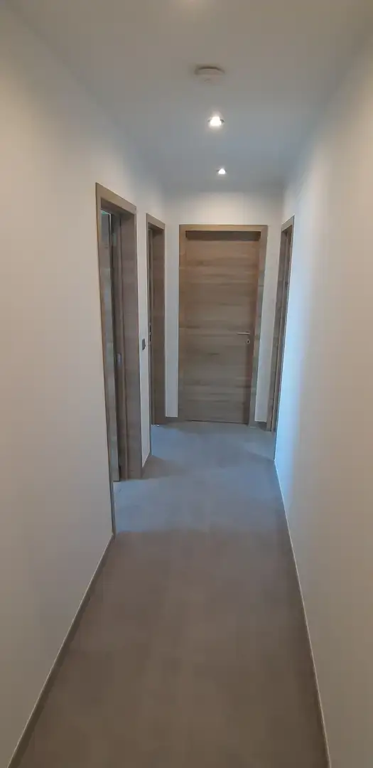 Couloir avec carrelage et portes en bois