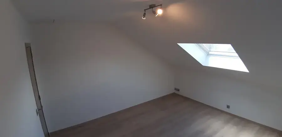 Chambre mansardée avec fenêtre de toit