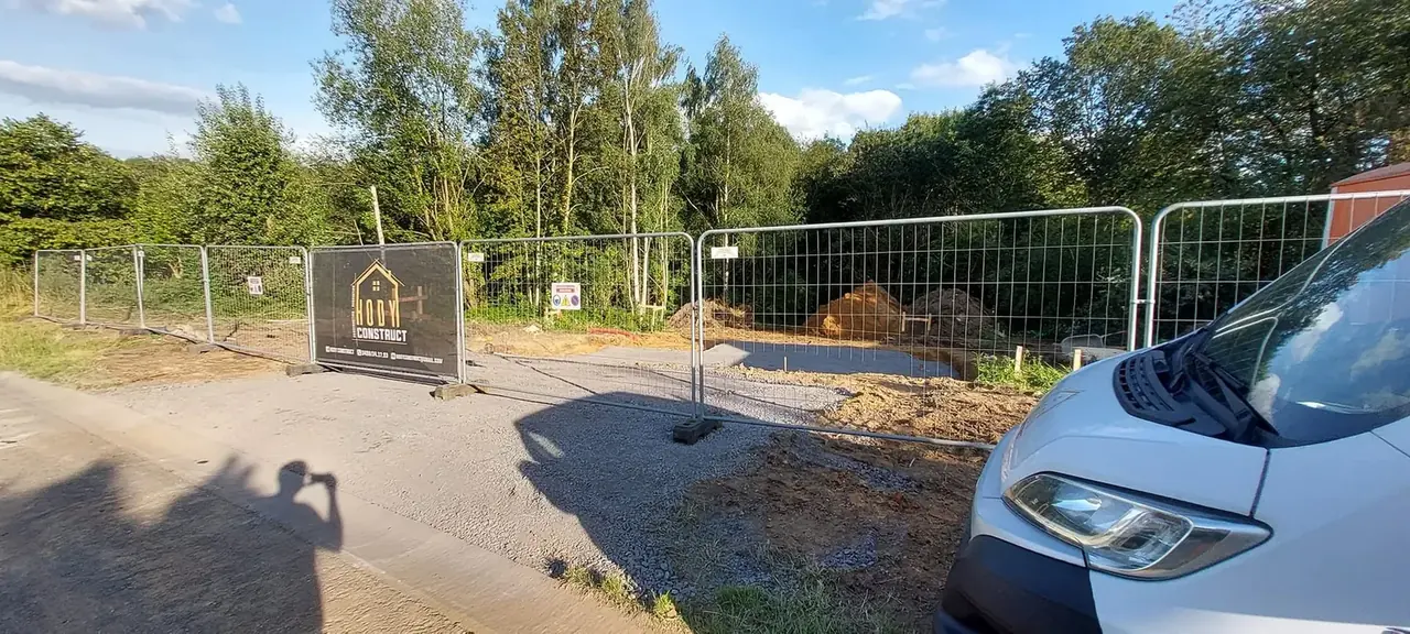 Panneau de chantier sur barrières devant une camionnette