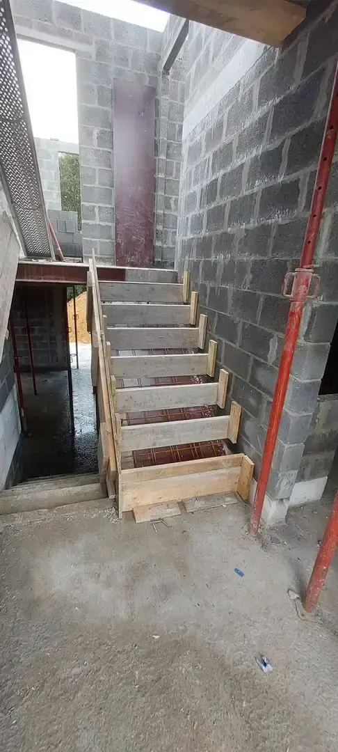 Escalier en bois provisoire dans la cage d'escalier en blocs