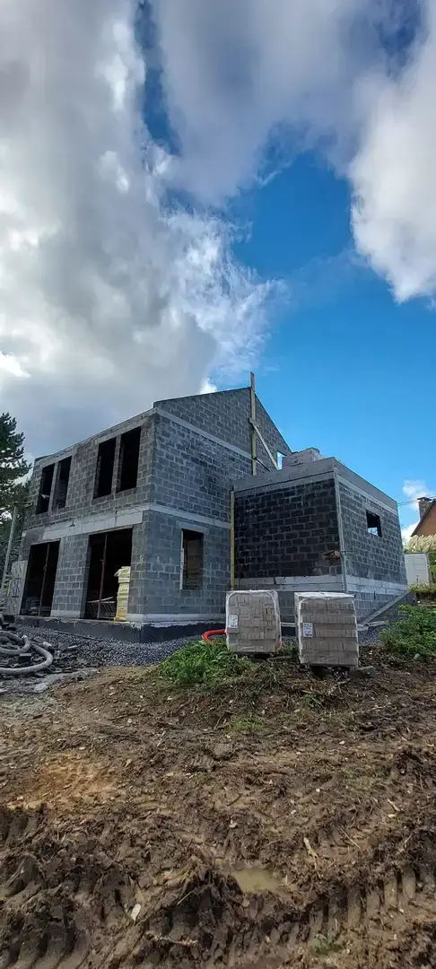 Maison en blocs avec échafaudage devant un ciel bleu