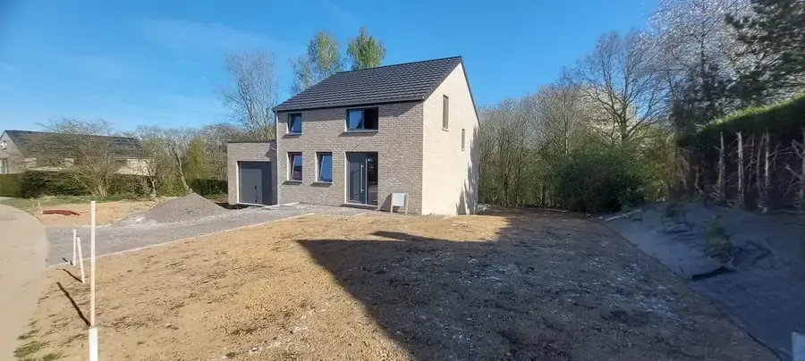 Maison terminée en briques beige, vue de la route