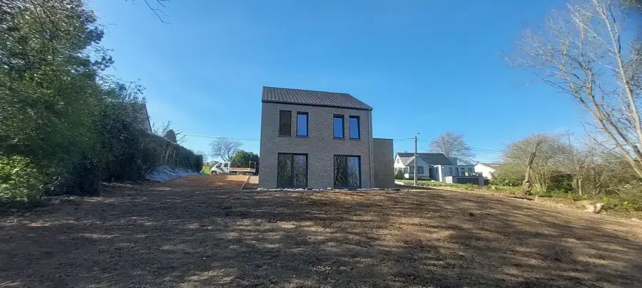 Maison en briques beige sur son terrain