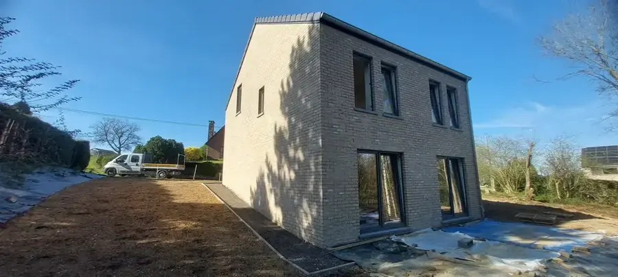 Maison en briques beige et ciel bleu, vue en angle