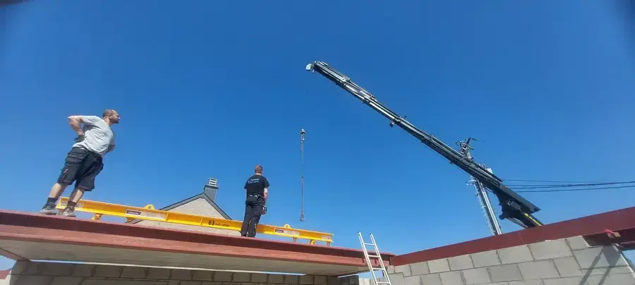 Toiture plate en cours de couverture avec grue