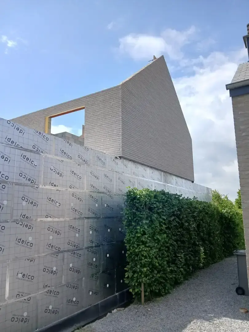 Mur de briques collées sur isolant, ciel bleu