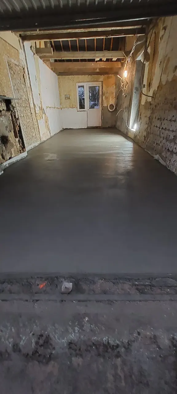 Couloir en longueur avec chape neuve et plafond en poutres