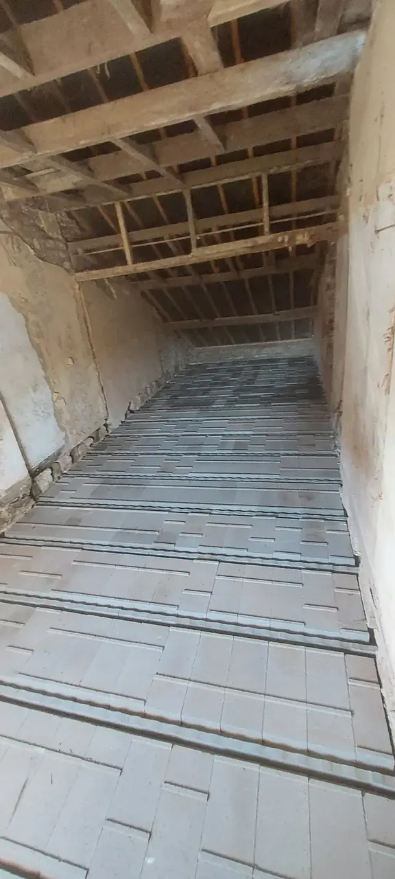 Plancher de hourdis et poutrelles vus d'un long couloir
