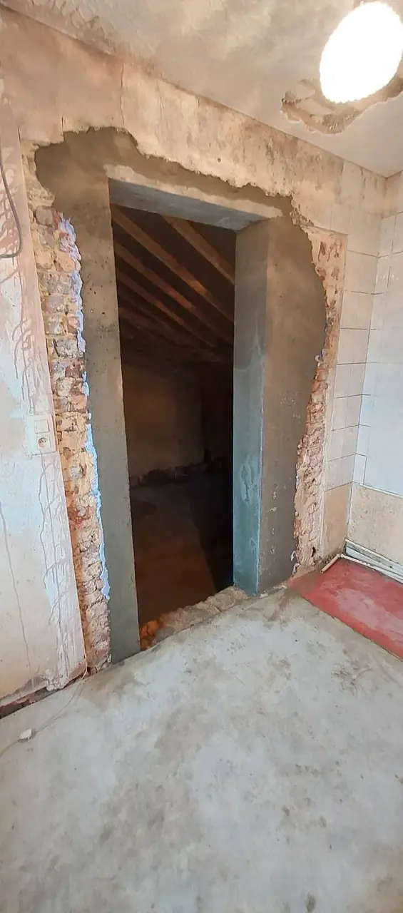 Ouverture encadrée dans un mur vers l'escalier