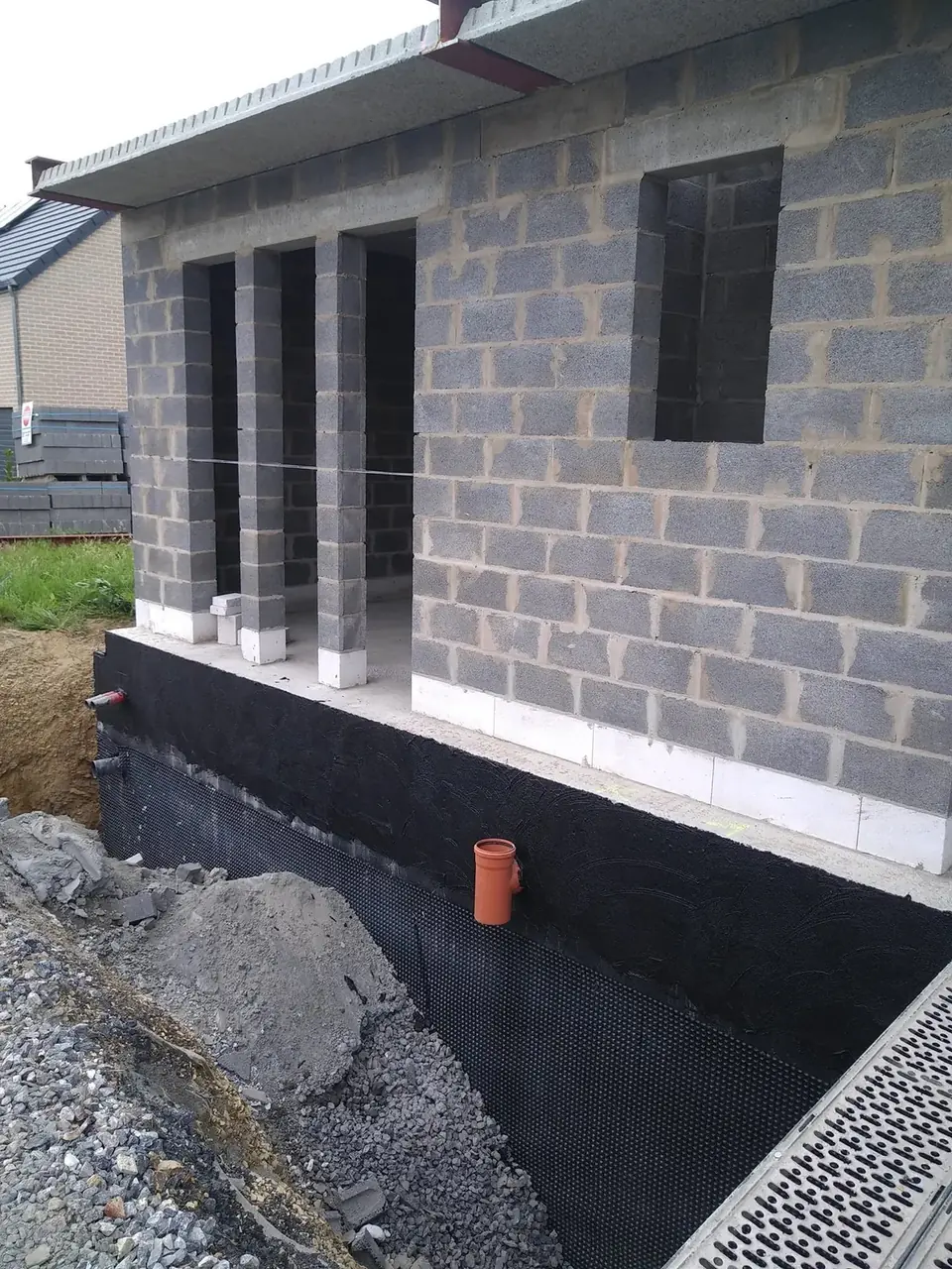 Angle de façade en blocs sur soubassement bitumé