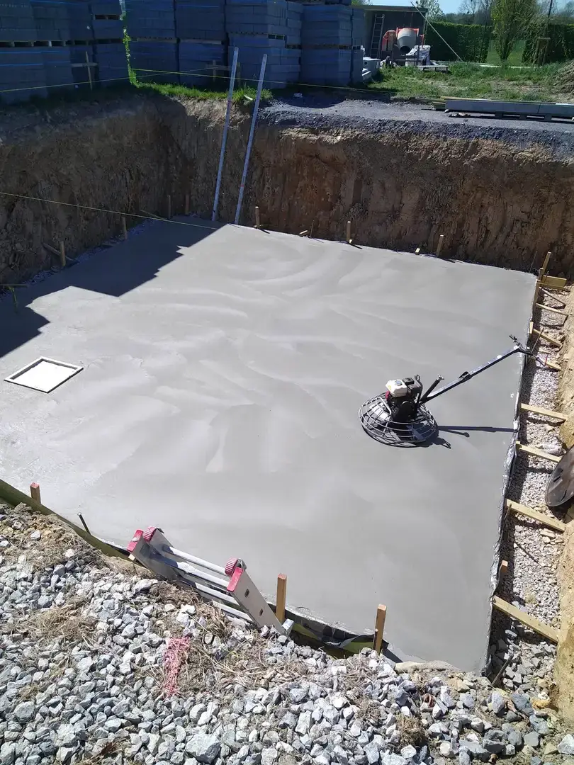 Dalle de béton lissée à l'hélicoptère dans la fouille