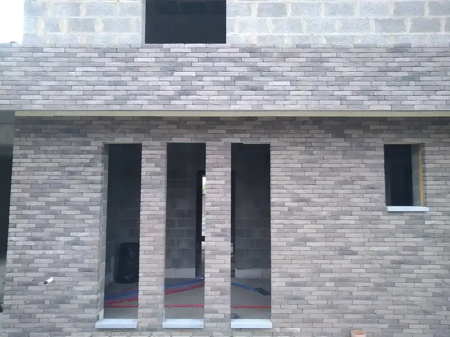 Façade en briques avec trois ouvertures verticales