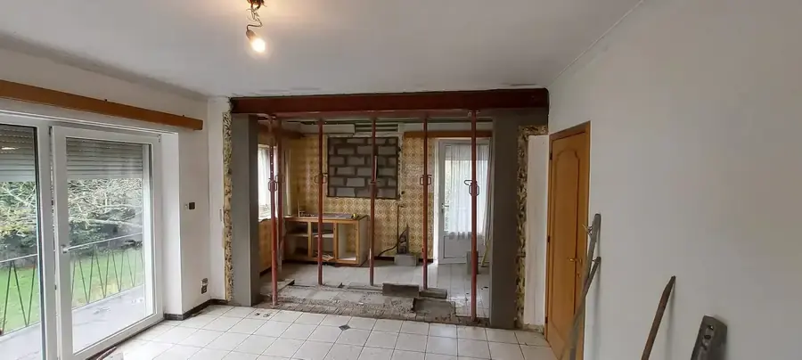 Salon avec grandes baies coulissantes et ouverture dans un mur, étais derrière