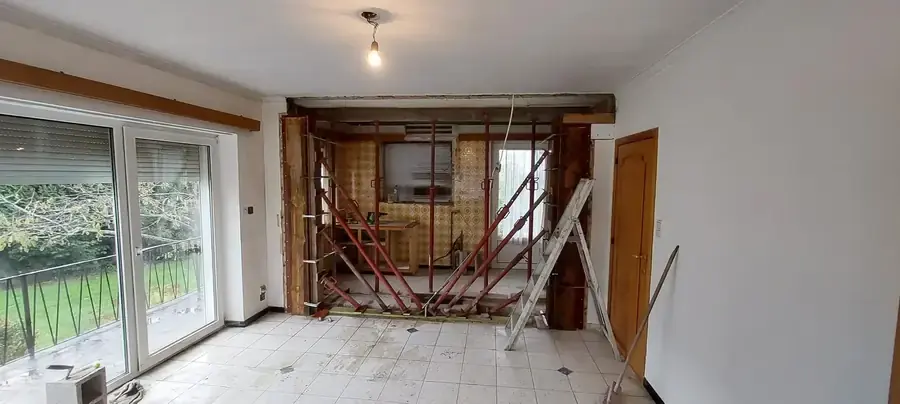 Salon avec ouverture dans un mur soutenue par des étais métalliques