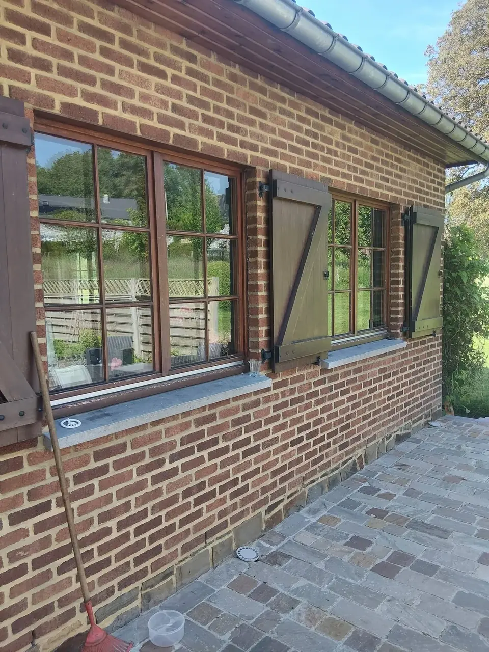 Fenêtre en bois avec volets dans un mur en briques