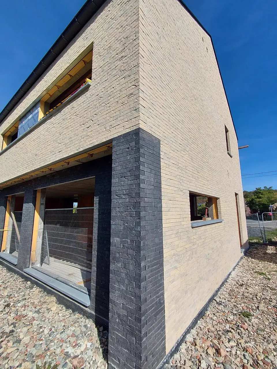 Façade en briques beige et briques noires, vue en contre-plongée