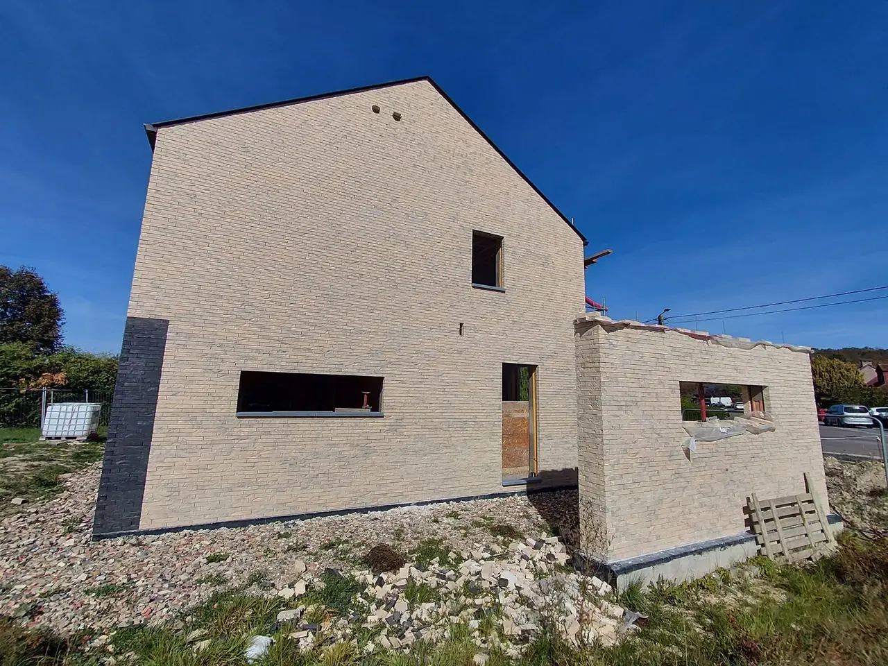 Façade pignon en briques beige avec ouvertures