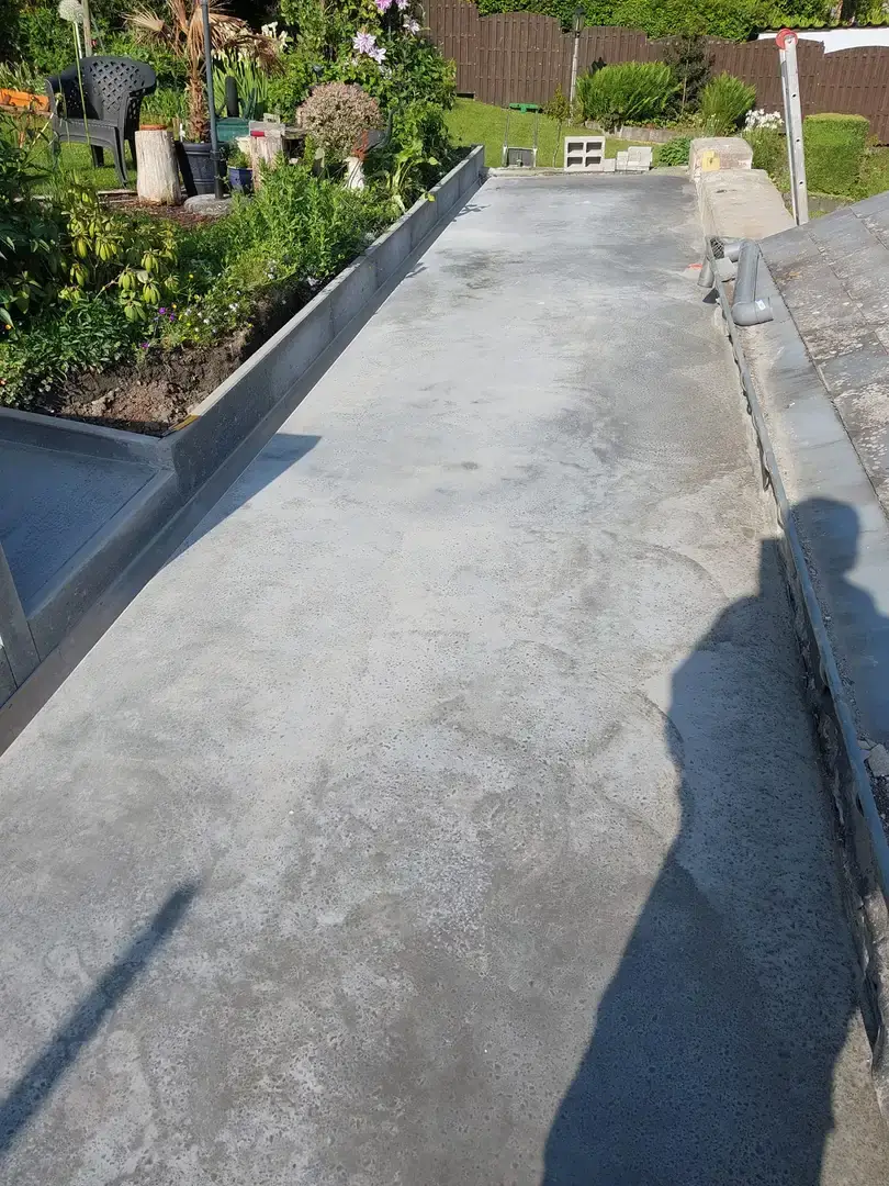 Terrasse de béton gris le long d'une plate-bande fleurie