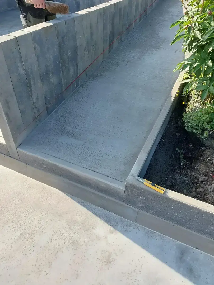 Terrasse de béton gris avec bordure et plate-bande