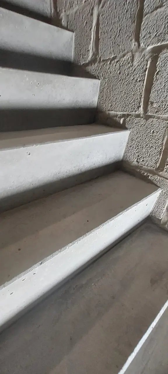 Marches d'un escalier en béton le long d'un mur de blocs