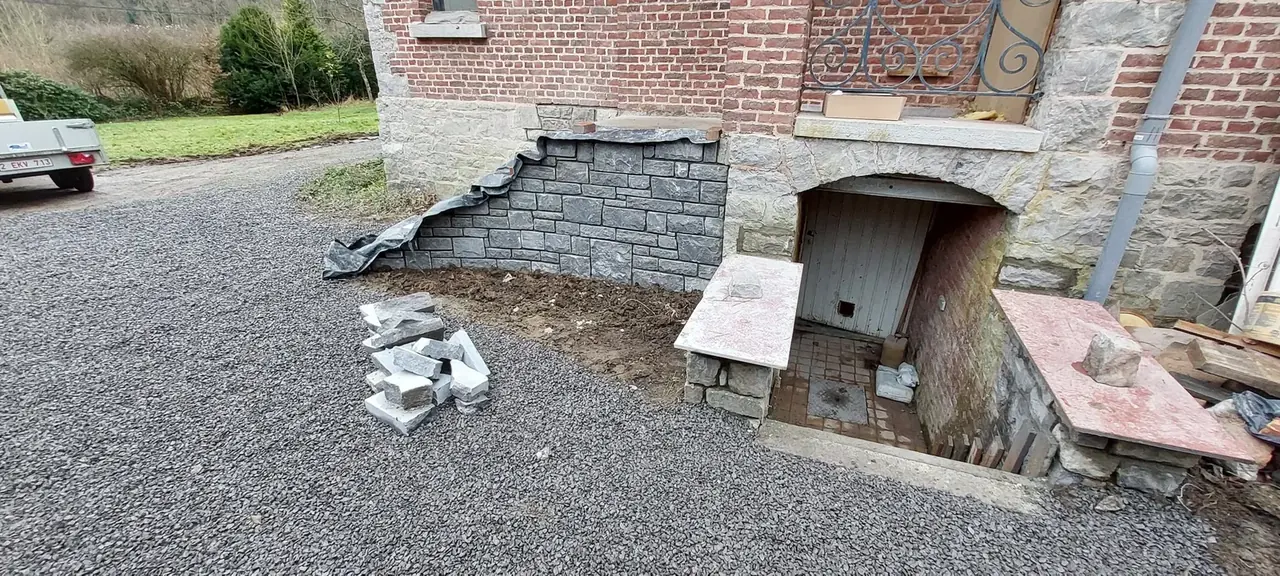 Entrée de cave en pierre devant la façade