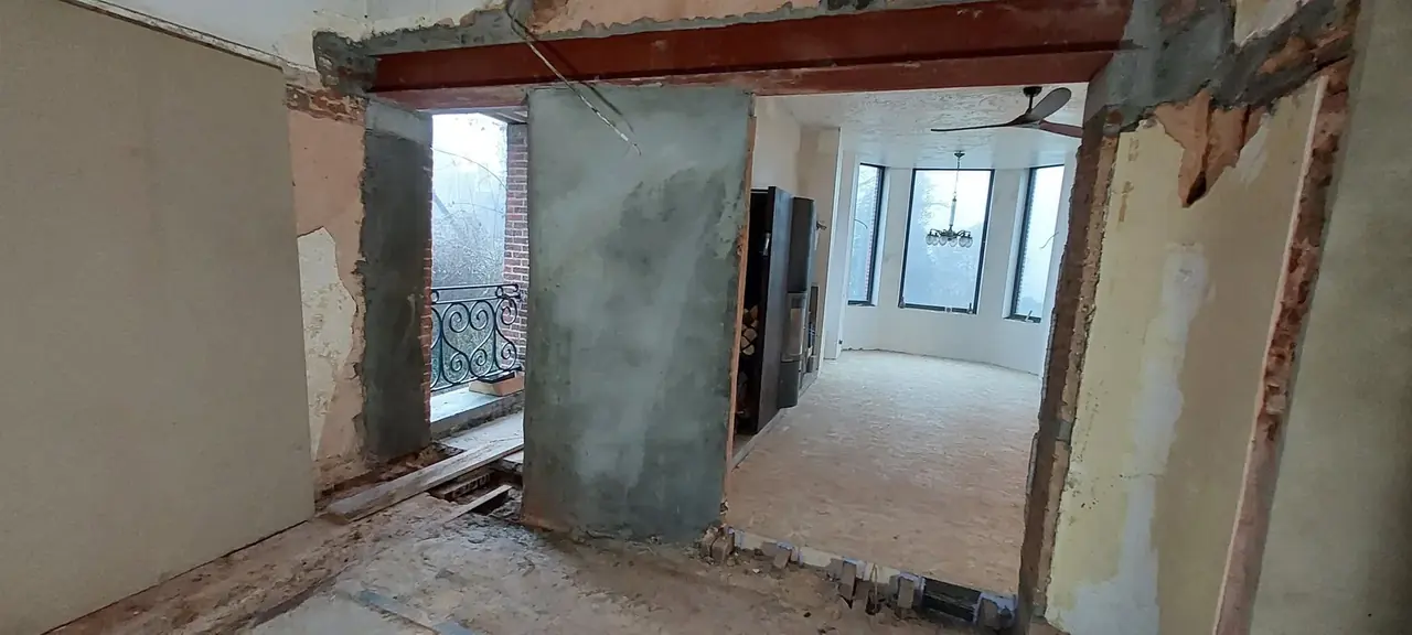 Passage et colonne en cours d'enduit dans une grande pièce