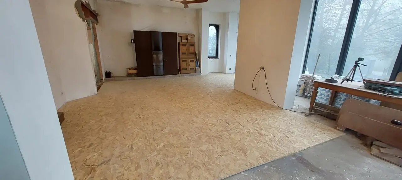 Grande pièce avec plancher OSB et poêle