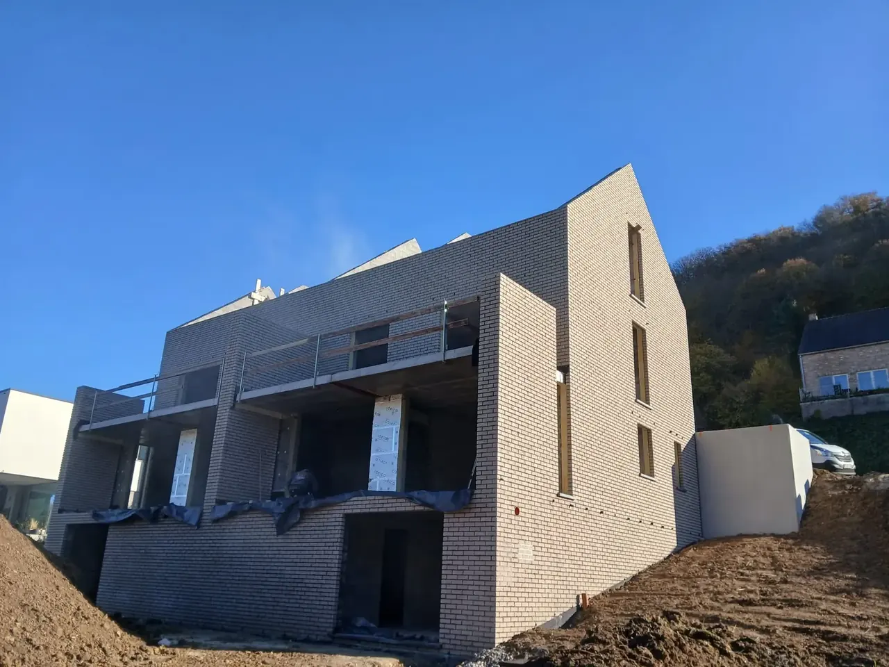 Maisons jumelées en briques beige avec balcon, vue en angle