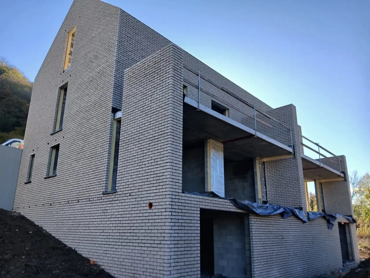 Maisons jumelées en briques beige avec balcons, ciel bleu