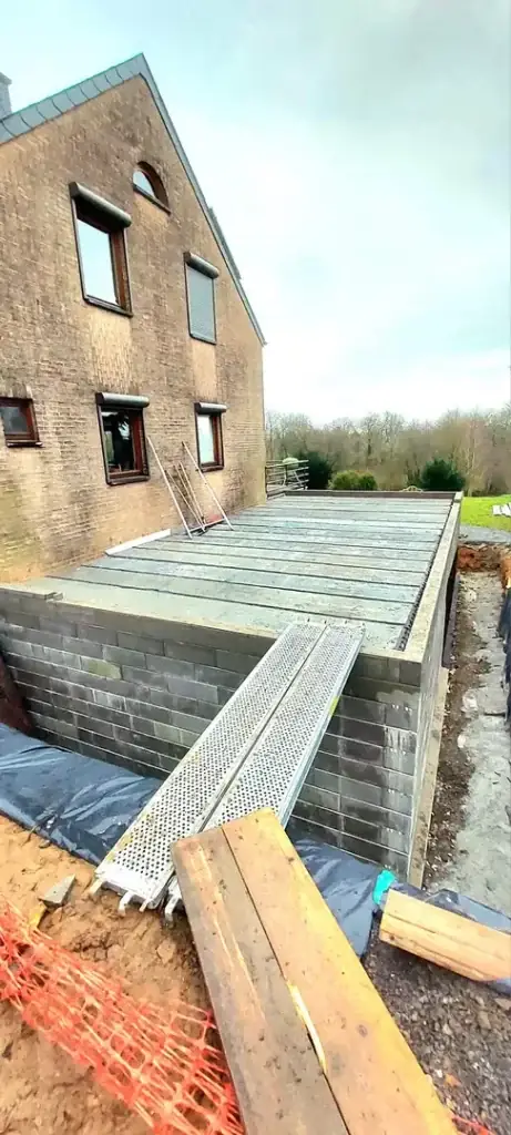 Façade d'une maison avec dalle en cours de réalisation et coffrage bois